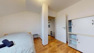 une chambre avec des murs blancs et un lit et un placard dans l'établissement Le nid perché Mulhouse, à Mulhouse