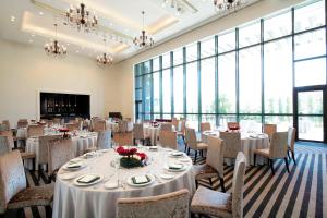 a banquet room with tables and chairs and large windows at The Westin Sendai in Sendai