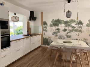 a kitchen with a table and chairs in a kitchen at Le cottage du Lenn in Louannec