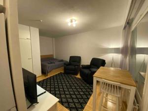 a living room with two chairs and a television at Saunallinen yksiö keskustassa in Pieksamaki +8 photos