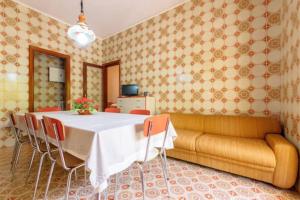 une salle à manger avec une table et un canapé dans l'établissement DX Appartamento Fiori d arancio, à Tonnara di Bonagia