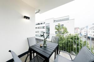 a small balcony with a wooden table and chairs at koCASA-Apartments 02, Design, City-Center Böblingen, Stellplatz, Balkon in Böblingen
