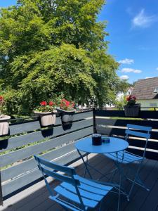 two chairs and a table on a deck with plants at Haus der Sonne in Soltau