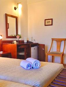 a bedroom with a bed and a desk and a mirror at Philoxenia in Kavála