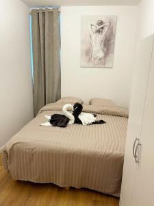 ein Schlafzimmer mit zwei Schwänen auf einem Bett in der Unterkunft RM-0 - Joli 2 pièces tout équipé au RDC à Mulhouse pour 1-3 pers in Mulhouse