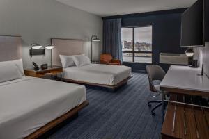 杰斐逊城Courtyard by Marriott Jefferson City的有两张床和一张书桌的酒店房间