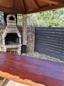 a patio with a stone fireplace and a wooden table at Apartment Sun & Sea in Krk