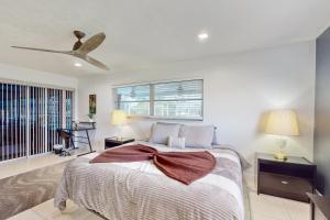 a bedroom with a bed and a ceiling fan at Modern Getaway in Cape Coral +16 photos