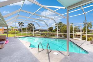 a large swimming pool with a glass roof at Modern Getaway in Cape Coral