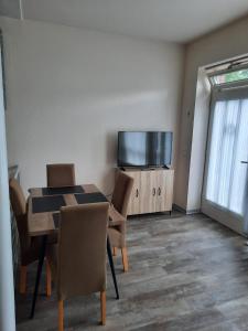 a dining room with a table and a flat screen tv at Ferienhaus Holzminden in Holzminden