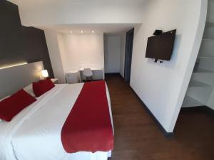 Un dormitorio con una cama grande y un televisor. en Oxford Hotel, en Montevideo