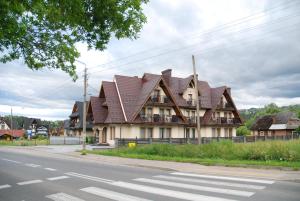 a large house with a brown roof on a street at "Czarna Turnia "Zakopane in Zakopane