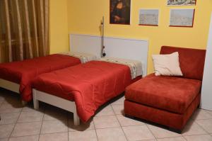 a room with two beds and a couch and a chair at Casa Dei Puzzle in Matera