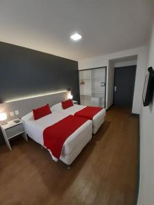 a bedroom with a large white bed with red sheets at Oxford Hotel in Montevideo