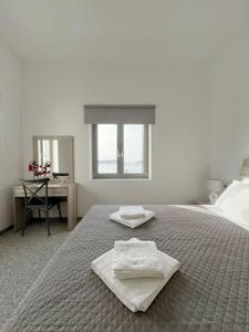 a bedroom with a bed with two towels on it at Linardo's Cycladic House in Naousa