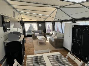 a living room in a tent with a couch and chairs at Przyczepa 2022 MOLO SURF in Jastarnia
