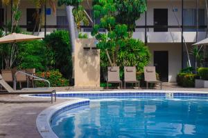 a swimming pool with chairs and a building at El Dorado in Los Mochis