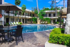 a hotel with a table and chairs next to a pool at El Dorado in Los Mochis