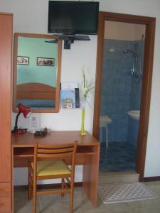 卡奧萊的住宿－Hotel Fornaro，一张桌子、椅子、镜子和淋浴