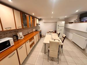 a kitchen with a table and chairs and a refrigerator at La Casa in Sibiu