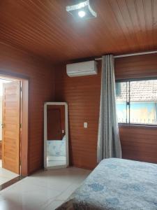 a bedroom with a large bed and a window at Urubici Maravilhas da Serra 1 in Urubici