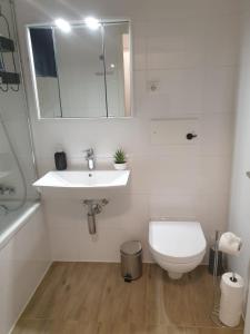 a white bathroom with a sink and a toilet at Bonn Lounge in Bonn +14 photos
