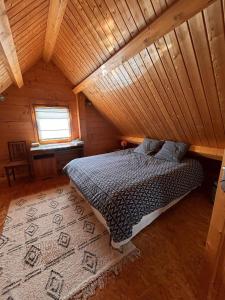 a bedroom with a bed in a wooden cabin at Maison écoresponsable classée 3 étoiles avec son jardin clos in Donzy