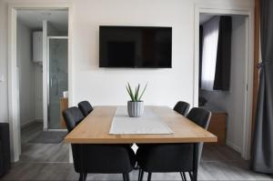 a dining room table with chairs and a television on a wall at Luxury mobile home INES in Drage