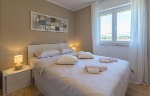 a bedroom with a white bed with towels on it at Beautiful Apartment In Karigador in Karigador