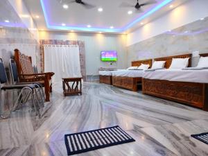 a room with two beds and a television in it at le falls 2 in Kuttālam
