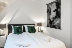 a bedroom with a large white bed with green pillows at 6-bed Aircon House Diaz 60m2, Many Bedrooms in Tilburg