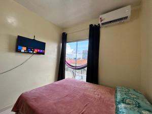 ein Schlafzimmer mit einem Bett und einem Fenster mit Aussicht in der Unterkunft Apart-Norte Flat Belém Aeroporto in Belém