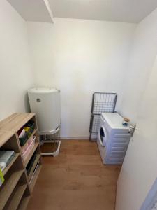 a bathroom with a washer and dryer in a room at Le petit Larros in Gujan-Mestras +3 photos