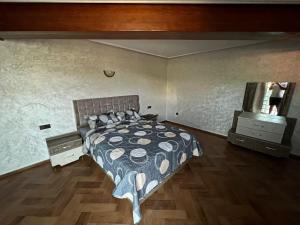 a bedroom with a bed and a dresser and a mirror at Villa cedra centre ville ifrane zéro six soixante-neuf soixante-huit 3828 in Ifrane