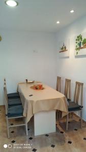 a dining room table with chairs and a table cloth at Apartamentos La Fuente Ribadeo in Ribadeo +18 photos