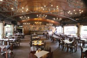 a dining room with tables and chairs and chandeliers at Queen Maria Estate Apartments Winery Restaurant in Demir Kapija