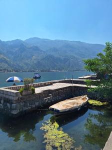 a boat in the water next to a stone wall at Old stone house Danka in Kotor +21 photos