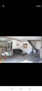 a living room with a staircase and a table at Duplex refait à neuf dans vieille bâtisse in Prades