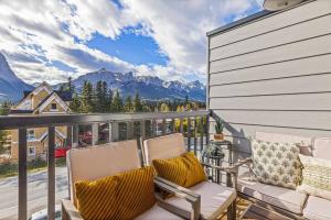 a balcony with two chairs and a view of mountains at K202 Hot tub, Pool, MTN view, AC, free parking in Canmore