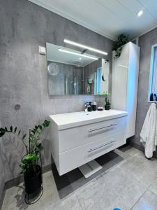 une salle de bains avec un lavabo blanc et un miroir dans l'établissement Ålesund sentrum apartment, à Ålesund 9 autres photos