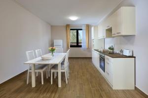 a kitchen and dining room with a table and chairs at Silver Cottage in Máriapócs