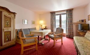 a hotel room with a table and chairs and a television at Alpenappartement Europa in Sankt Johann in Tirol