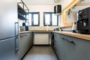 eine Küche mit weißen Schränken und einer Arbeitsplatte in der Unterkunft The Bear Chalet with Private Hot Tub in Buşteni