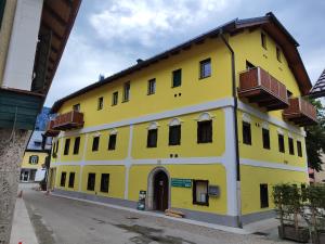 un edificio amarillo con balcones en una calle en Hostel Bad Goisern, en Bad Goisern