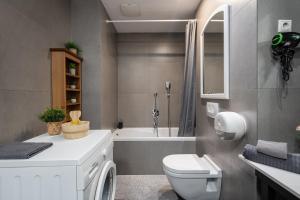 a bathroom with a toilet and a bath tub at City Center Wellness Suites - POOL-GYM-PARKING in Budapest +26 photos