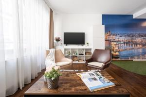 a living room with a table and chairs and a tv at City Center Wellness Suites - POOL-GYM-PARKING in Budapest