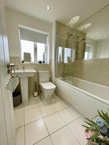 a bathroom with a toilet and a sink and a shower at Stunning Beachfront House in Felixstowe +15 photos