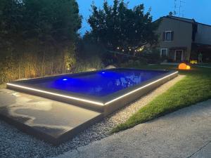 a swimming pool with blue water in a yard at DeLax B&B - adults only in Solferino
