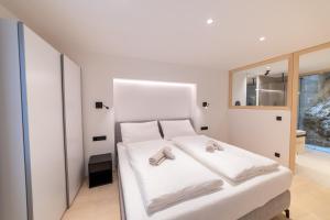 a bedroom with a white bed with slippers on it at Rock Salzburg in Salzburg