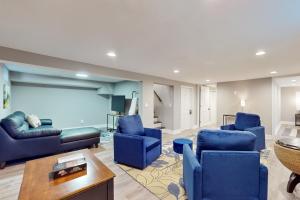 a living room with blue chairs and a couch at Poolside Paradise in South Haven